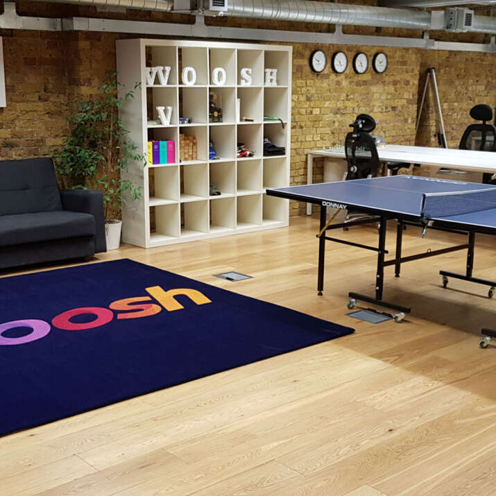 Bright Spectrum Colours Company logo translated into two hand tufted rugs for this office area.